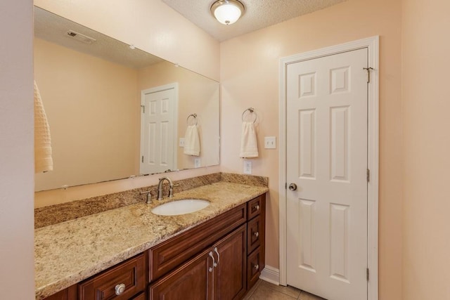 122 Warwick St, La Place, LA 70068 - bathroom featuring vanity, a textured ceiling, and tile patterned floors