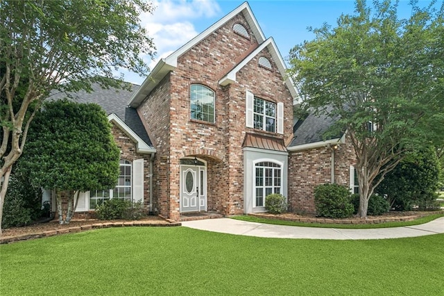 89 Catalpa Trce, Covington, LA 70433 - traditional home featuring brick siding, a front yard, a shingled roof, and a standing seam roof