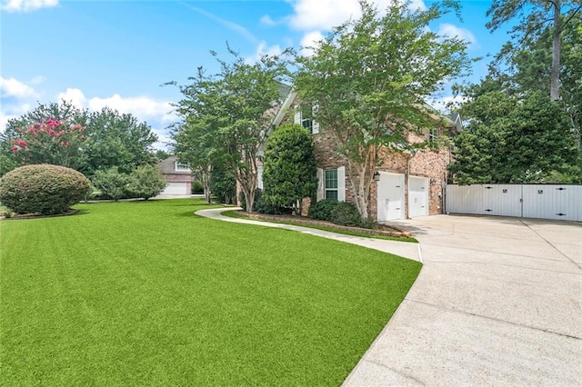 89 Catalpa Trce, Covington, LA 70433 - view of front of house with concrete driveway, a garage, a gate, a front yard, and brick siding