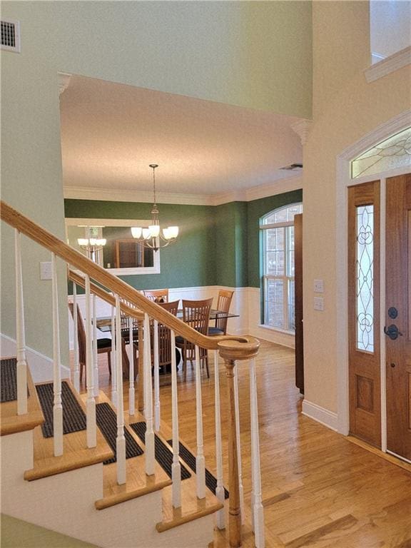 89 Catalpa Trce, Covington, LA 70433 - foyer entrance featuring a chandelier, wood finished floors, crown molding, and stairway