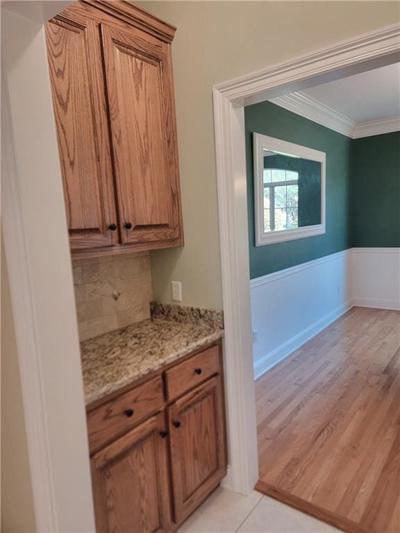 89 Catalpa Trce, Covington, LA 70433 - bar area featuring ornamental molding, a wainscoted wall, light wood finished floors, and backsplash