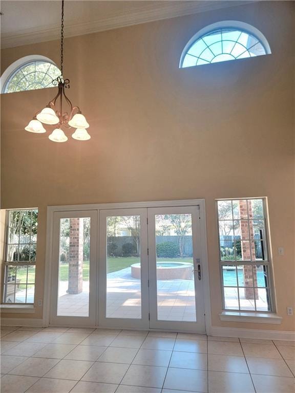 89 Catalpa Trce, Covington, LA 70433 - doorway to outside featuring a high ceiling, a chandelier, light tile patterned floors, and ornamental molding