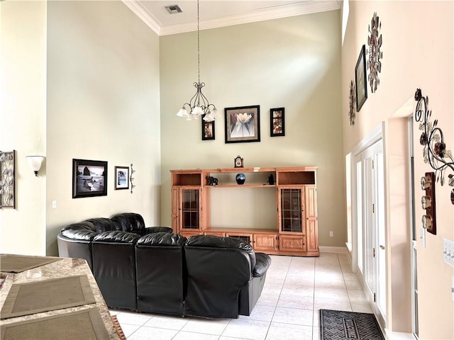 89 Catalpa Trce, Covington, LA 70433 - living area featuring a towering ceiling, crown molding, a chandelier, and light tile patterned flooring