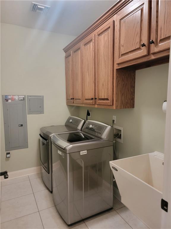 89 Catalpa Trce, Covington, LA 70433 - laundry area with electric panel, independent washer and dryer, cabinet space, and light tile patterned floors