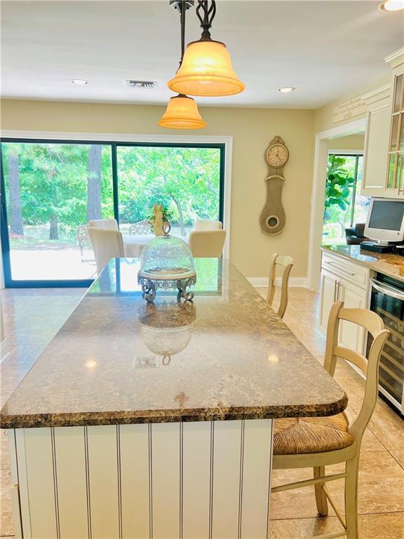 14 Riverbend Ln, Covington, LA 70433 - kitchen featuring healthy amount of natural light, wine cooler, white cabinets, a kitchen island, and recessed lighting