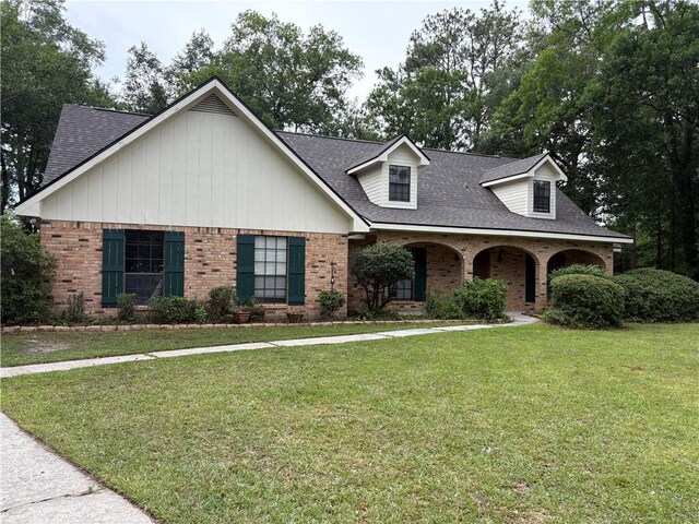 101 E Queensbury Dr, Slidell, LA 70461 - view of front facade featuring brick siding, roof with shingles, a front yard, and covered porch