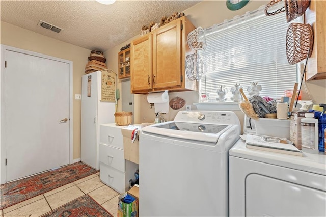 101 E Queensbury Dr, Slidell, LA 70461 - laundry area featuring cabinet space, independent washer and dryer, a textured ceiling, and light tile patterned floors