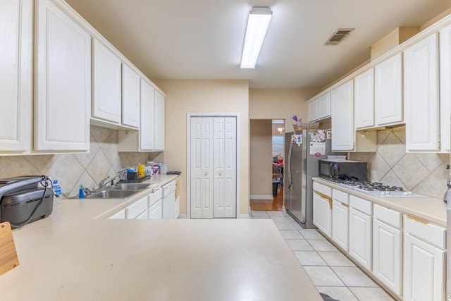 2143 Summertree Dr, Slidell, LA 70460 - kitchen featuring white appliances, light countertops, white cabinetry, tasteful backsplash, and light tile patterned floors