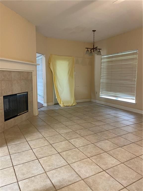 2143 Summertree Dr, Slidell, LA 70460 - unfurnished living room with light tile patterned floors, a chandelier, and a tiled fireplace
