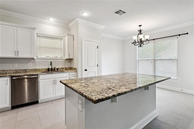 386 Knollwood Ln, Slidell, LA 70458 - kitchen with stainless steel dishwasher, light stone counters, white cabinetry, light tile patterned floors, and a kitchen breakfast bar