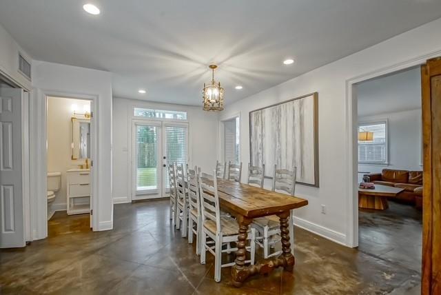 446 Glendale Dr, Metairie, LA 70001 - dining room featuring finished concrete floors, a chandelier, recessed lighting, and french doors