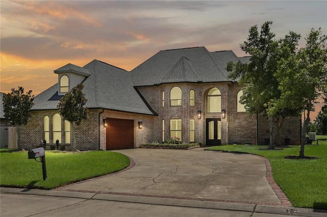 172 River Oaks Dr, La Place, LA 70068 - french provincial home with a garage, driveway, a lawn, and brick siding