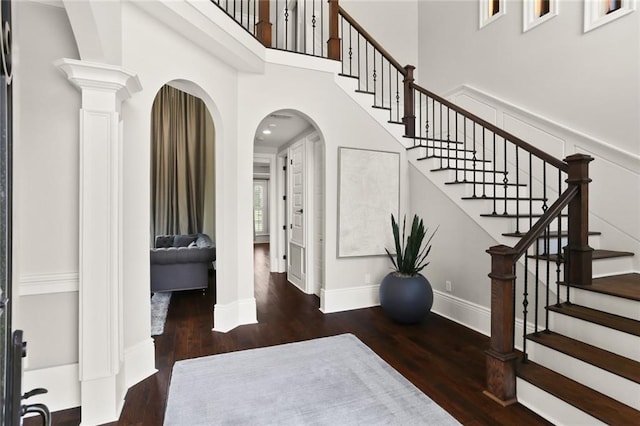 172 River Oaks Dr, La Place, LA 70068 - foyer entrance featuring wood finished floors, a high ceiling, arched walkways, stairs, and ornate columns