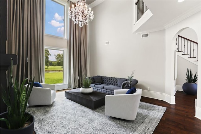 172 River Oaks Dr, La Place, LA 70068 - living area featuring wood finished floors, crown molding, arched walkways, a chandelier, and a high ceiling