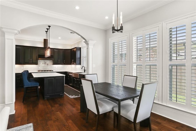 172 River Oaks Dr, La Place, LA 70068 - dining room featuring decorative columns, arched walkways, dark wood-type flooring, recessed lighting, and crown molding