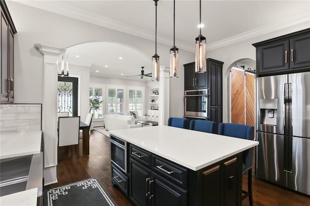 172 River Oaks Dr, La Place, LA 70068 - kitchen featuring stainless steel appliances, arched walkways, a ceiling fan, a breakfast bar, and dark wood-style floors