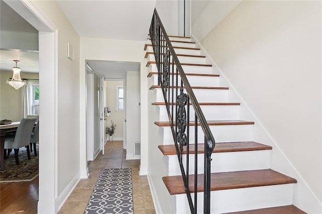 5237 Meadowdale St, Metairie, LA 70006 - stairway featuring a chandelier and baseboards