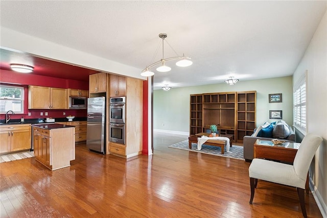 5237 Meadowdale St, Metairie, LA 70006 - kitchen featuring stainless steel appliances, open floor plan, dark countertops, dark wood finished floors, and a center island