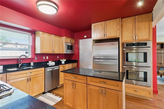 5237 Meadowdale St, Metairie, LA 70006 - kitchen featuring appliances with stainless steel finishes, light wood finished floors, a kitchen island, and dark stone counters