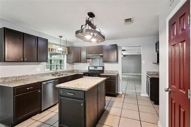 4046 Riviera Dr, Slidell, LA 70458 - kitchen featuring appliances with stainless steel finishes, under cabinet range hood, light tile patterned floors, and a center island