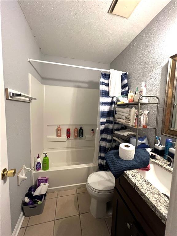 4325 Loire Dr, Kenner, LA 70065 - bathroom with a textured ceiling, vanity, shower / tub combo, tile patterned flooring, and a textured wall