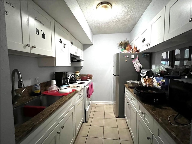 4325 Loire Dr, Kenner, LA 70065 - kitchen with white electric stove, a textured ceiling, under cabinet range hood, light tile patterned flooring, and white cabinetry