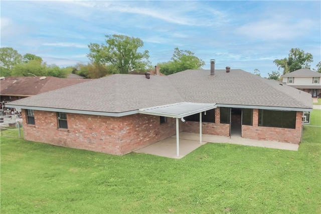2137 Carmel Valley Dr, La Place, LA 70068 - rear view of house with a lawn, a shingled roof, a patio area, and brick siding