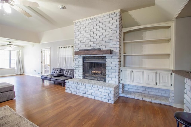 2137 Carmel Valley Dr, La Place, LA 70068 - living room with a ceiling fan, a fireplace, dark wood-style flooring, and built in shelves