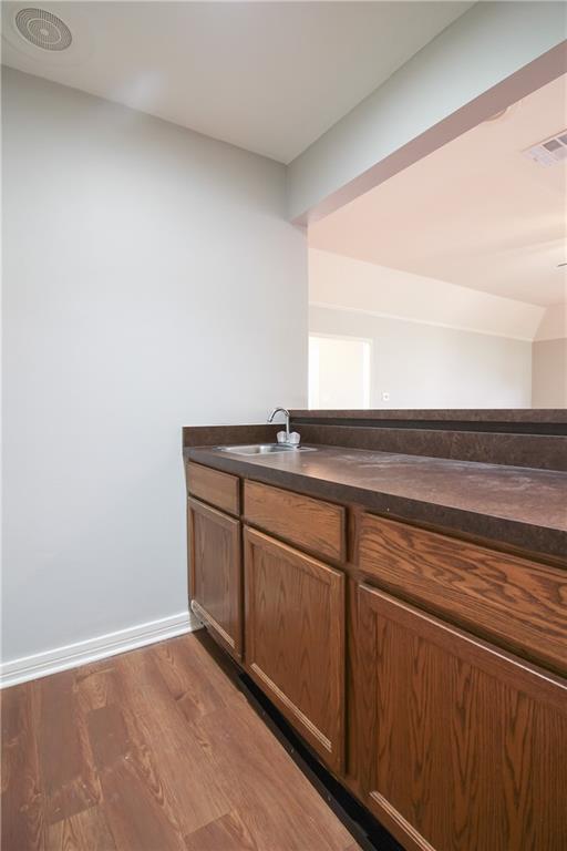 2137 Carmel Valley Dr, La Place, LA 70068 - bar featuring a sink and wood finished floors