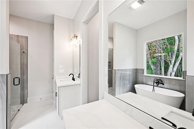 1023 W 19th Ave, Covington, LA 70433 - full bathroom featuring vanity, a shower stall, a soaking tub, tile walls, and wainscoting