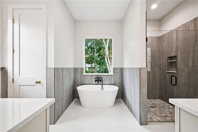 1023 W 19th Ave, Covington, LA 70433 - bathroom featuring a shower stall, a freestanding tub, vanity, a wainscoted wall, and tile patterned flooring