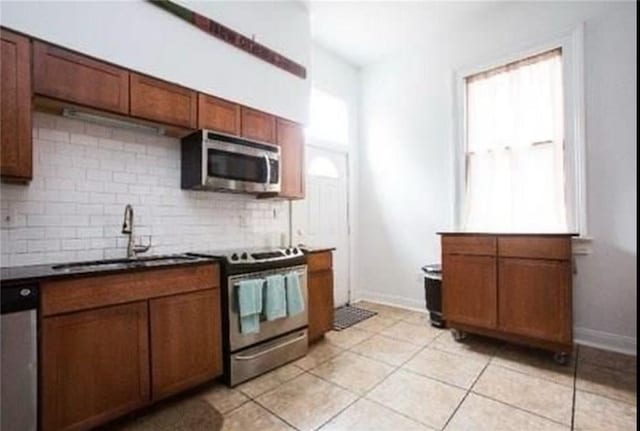 252224 General Pershing St, New Orleans, LA 70115 - kitchen with appliances with stainless steel finishes, tasteful backsplash, light tile patterned floors, and dark countertops