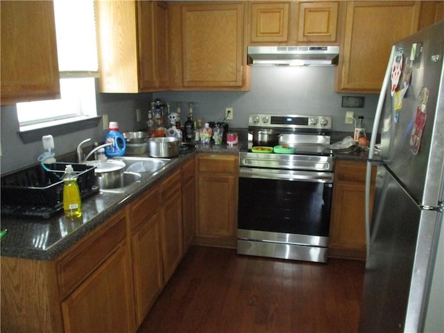 9025 Hickory St, New Orleans, LA 70118 - kitchen with appliances with stainless steel finishes, under cabinet range hood, dark wood-style floors, brown cabinetry, and dark countertops