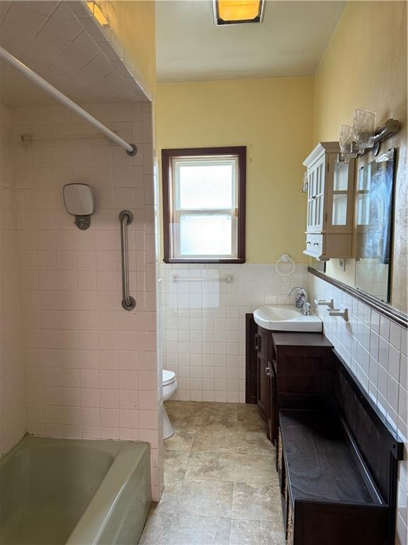490 Lions St, Jefferson, LA 70121 - bathroom featuring vanity, tile walls, and shower / washtub combination