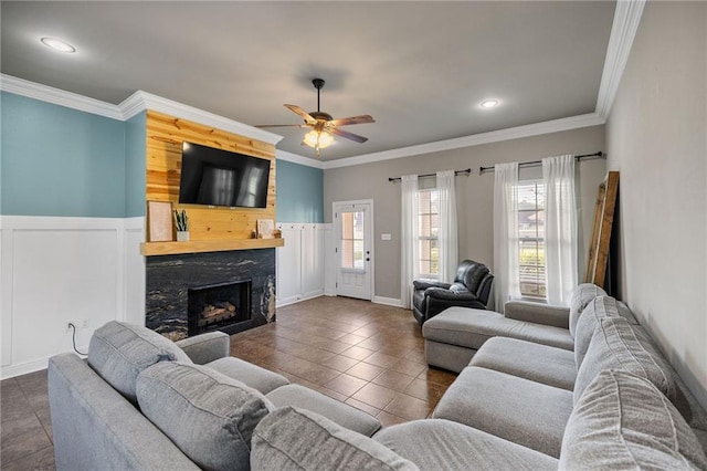 42467 Harlan Pl, Ponchatoula, LA 70454 - tiled living area with a fireplace, a ceiling fan, crown molding, recessed lighting, and wainscoting