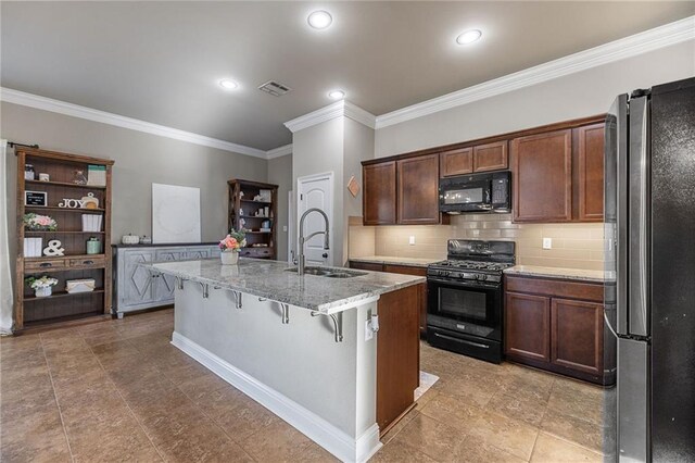 42467 Harlan Pl, Ponchatoula, LA 70454 - kitchen featuring black appliances, crown molding, a breakfast bar area, light stone counters, and tasteful backsplash