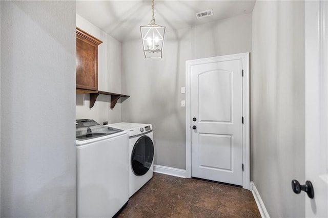 42467 Harlan Pl, Ponchatoula, LA 70454 - laundry room with washing machine and dryer, a chandelier, and stone finish floors