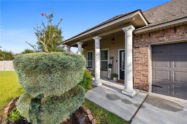 42467 Harlan Pl, Ponchatoula, LA 70454 - view of exterior entry featuring covered porch, brick siding, a garage, and a shingled roof