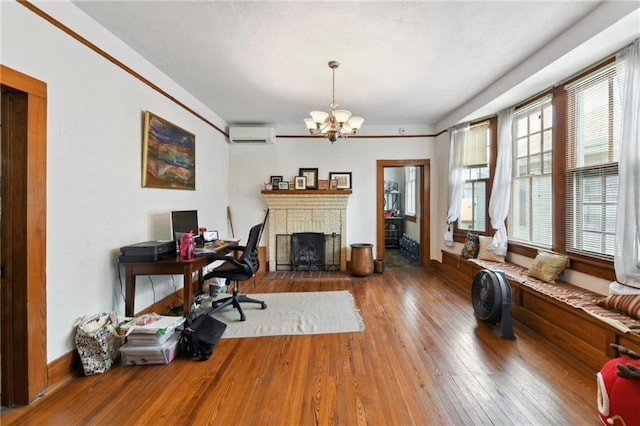 1815 S White St, New Orleans, LA 70125 - living area featuring hardwood / wood-style flooring, a chandelier, a wall mounted air conditioner, and a brick fireplace