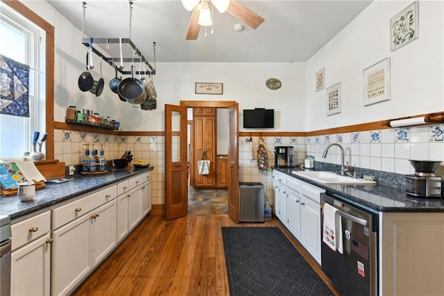 1815 S White St, New Orleans, LA 70125 - kitchen with dishwasher, tile walls, dark wood finished floors, a ceiling fan, and white cabinets