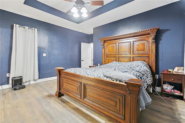 4320 Alba Rd, New Orleans, LA 70129 - bedroom featuring wood finished floors, a textured wall, a tray ceiling, and a ceiling fan