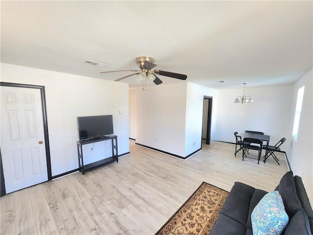 106 Treuil Ln, Belle Chasse, LA 70037 - living area featuring light wood finished floors, a chandelier, and a ceiling fan