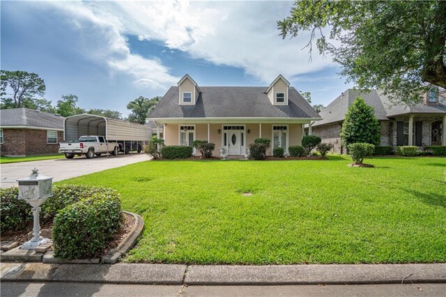 119 Gondrella Dr, Belle Chasse, LA 70037 - cape cod home featuring a detached carport, concrete driveway, covered porch, and a front lawn