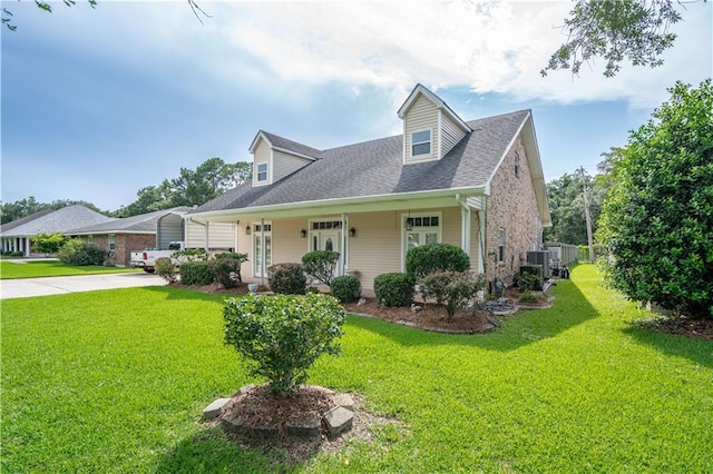 119 Gondrella Dr, Belle Chasse, LA 70037 - new england style home featuring a front lawn, concrete driveway, a shingled roof, and brick siding