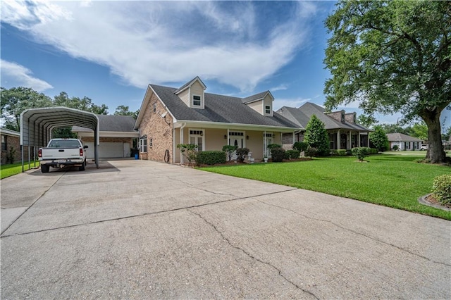 119 Gondrella Dr, Belle Chasse, LA 70037 - cape cod house featuring driveway, a front yard, a detached carport, and brick siding