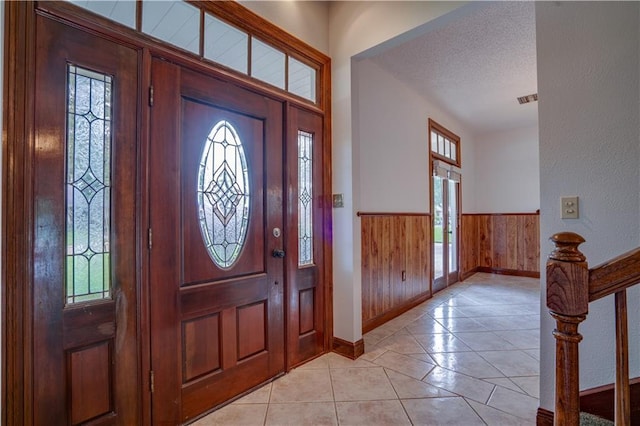 119 Gondrella Dr, Belle Chasse, LA 70037 - entrance foyer featuring a wainscoted wall, healthy amount of natural light, a textured ceiling, wooden walls, and light tile patterned flooring