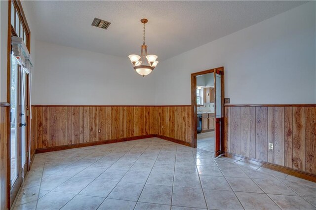 119 Gondrella Dr, Belle Chasse, LA 70037 - empty room featuring wainscoting, a chandelier, wooden walls, and light tile patterned flooring