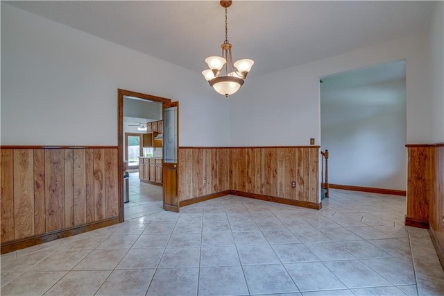 119 Gondrella Dr, Belle Chasse, LA 70037 - spare room with wainscoting, wood walls, a chandelier, and light tile patterned flooring