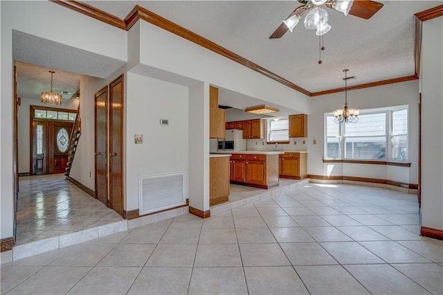 119 Gondrella Dr, Belle Chasse, LA 70037 - kitchen featuring a chandelier, light tile patterned floors, light countertops, crown molding, and brown cabinets