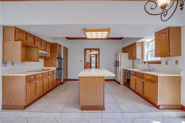 119 Gondrella Dr, Belle Chasse, LA 70037 - kitchen with black appliances, a center island, light countertops, under cabinet range hood, and a textured ceiling